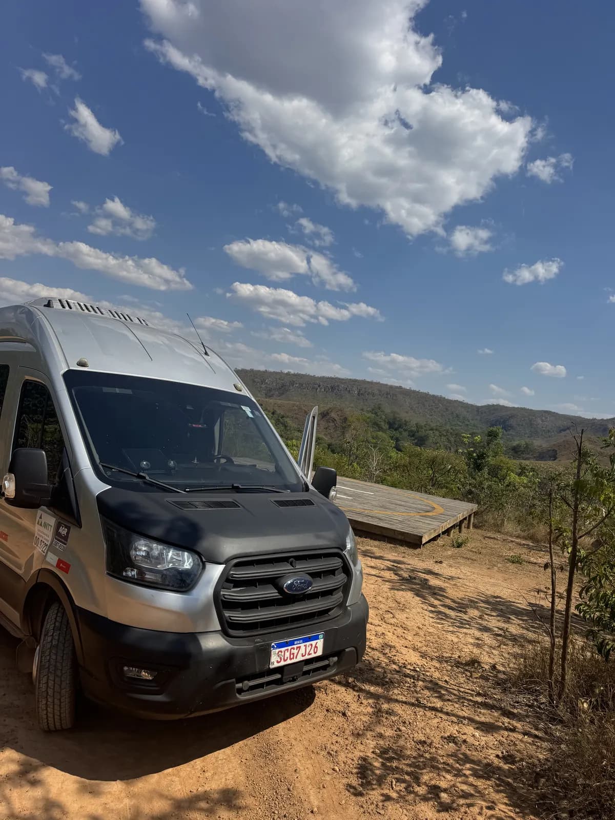 Frente da van executiva da Auge em estrada de terra com céu azul
